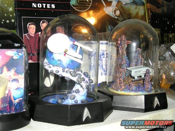 Star Trek display with a model Enterprise and a shuttlecraft on rocky terrain under glass domes
