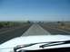 1969 Mercury Cougar - View from inside a vehicle driving on a highway with a clear blue sky and distant landscape.
