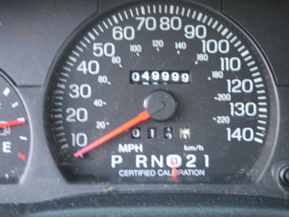 Car dashboard showing odometer reading 049999 and trip meter 0166, with P R N D 2 1 gear selector