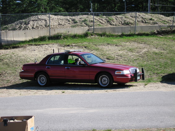 Red 1991 Ford Crown Victoria LTD with light bar and push bumper, side view