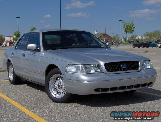 Silver 2002 Ford Crown Victoria parked in a lot, front 3/4 view, clean condition