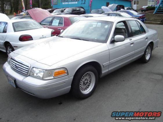 Silver 2002 Ford Crown Victoria sedan, front 3/4 view, parked on asphalt lot