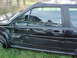 1987 Volkswagen Scirocco - A black car with extensive damage to its side and door sits in the grass.
