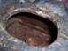 1978 Ford Bronco - Detail of heavily corroded metal, showing a circular opening with a bolt head within.