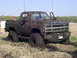 1994 Ford F-250 - This heavily mud-caked pickup truck appears to be stuck in a field, with the phrase 'TEARIN' IT UP' visible on its grille.
