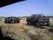 1994 Ford F-250 - Muddy trucks are stuck in a field under a clear blue sky.