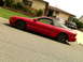1993 Ford Probe - Red 1993 Ford Probe parked curbside in front of a house with other vehicles visible.