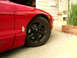 1993 Ford Probe - A close-up view of the front fender and wheel of a red sports car.