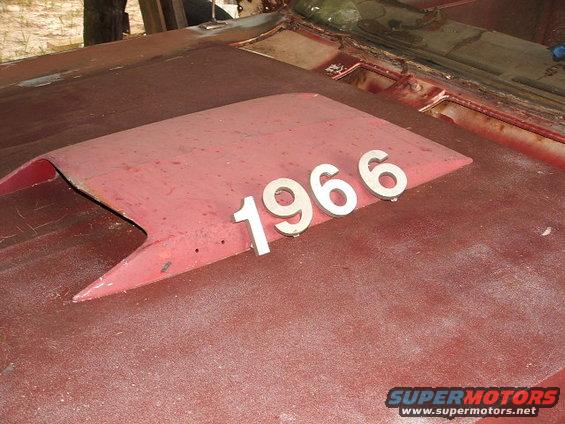 Red hood scoop with 1966 numbers on a rusty vehicle