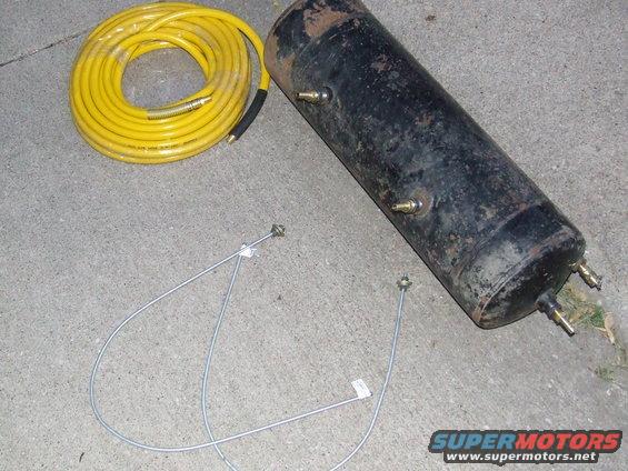 Air tank and yellow coiled hose on concrete