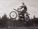 1968 Ford Ranchero - A rider soars through the air on a dirt bike, with a forest in the background.