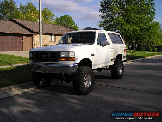 White lifted 1990 Ford Bronco parked on suburban street