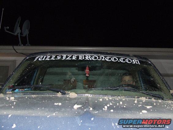 Ford Bronco windshield with "FULLSIZEBRONCO.COM" sticker and a person visible inside