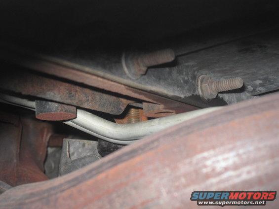 Underbody view of exhaust pipe and rusted bolts