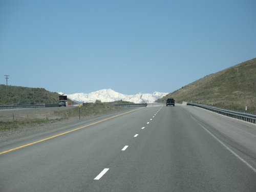 Highway driving scene with a truck in the distance and a dark SUV ahead