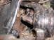 1985 GMC Jimmy - This image shows a close-up view of a damaged metal component, likely part of a vehicle's drivetrain or suspension system.