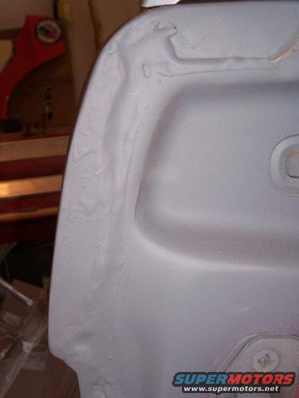 Primer-coated fender with visible seam and mounting point