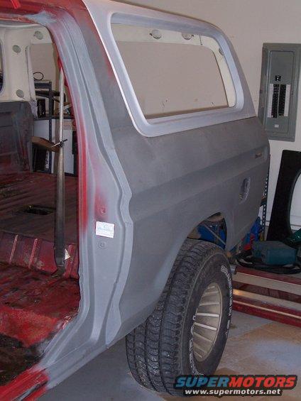 1978 Ford Bronco rear quarter panel, gray primer, red interior, in garage