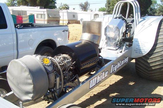 Jet dragster labeled 'White Lightning' next to a white pickup truck