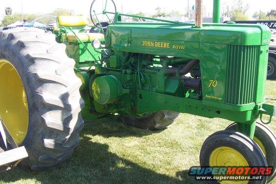 Green John Deere tractor with yellow wheels and seat, showing '70' on the side