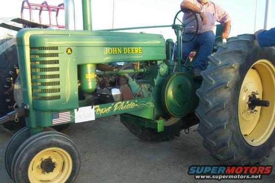 Green John Deere tractor with yellow wheels and "Pope's Pride" painted on the side