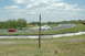 1993 Ford Mustang - A white 1993 Ford Mustang navigates a turn on a race track, with a red car visible in the background.