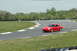 1993 Ford Mustang - A red Porsche 911 navigates a turn on a race track during the day.
