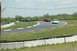 1993 Ford Mustang - Multiple cars are seen on a race track during a sunny day.