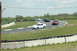 1993 Ford Mustang - Multiple vehicles compete on a winding race track under a cloudy sky.