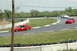 1993 Ford Mustang - A red 1993 Ford Mustang races on a track, with another car visible in the background.