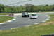1993 Ford Mustang - Cars compete on a winding race track under a cloudy sky.