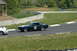 1993 Ford Mustang - A dark blue coupe with white racing stripes and the number 84 on its side drives on a track.