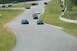 1993 Ford Mustang - A black 1993 Ford Mustang navigates a turn on a race track alongside other vehicles.