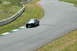1993 Ford Mustang - A black 1967 Ford Mustang with white racing stripes navigates a curve on a race track.