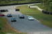 1993 Ford Mustang - Multiple Ford Mustangs race on a track, with a white Mustang in the foreground.