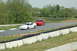 1993 Ford Mustang - Two Ford Mustangs are seen on a race track during a sunny day.