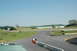 1993 Ford Mustang - A view of a race track on a clear day, showing the track, barriers, and surrounding buildings.