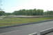 1993 Ford Mustang - A race track scene with a single car in the distance on a sunny day.
