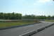 1993 Ford Mustang - A view of a winding race track with concrete barriers and surrounding trees on a clear day.