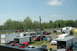 1993 Ford Mustang - A busy scene at a race track, with many vehicles and trailers parked on the grass.