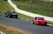1993 Ford Mustang - A red 1993 Ford Mustang hatchback competes on a race track alongside another vehicle.