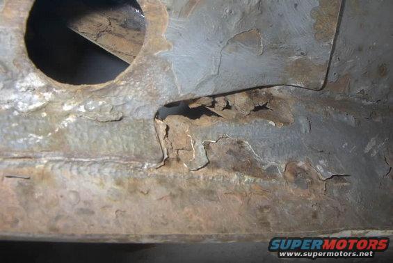 rusted frame section with hole and peeling paint