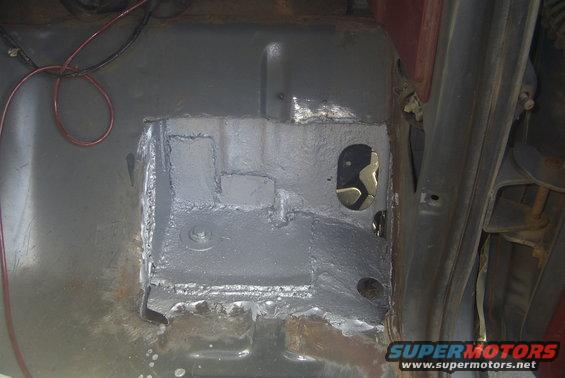 Undercarriage repair on a vehicle, showing patched metal and wiring