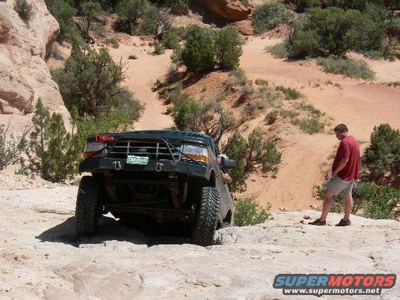 moab2006wipeouthill09.jpg Nathan making fun of me getting stopped and needing a strap.  It's pretty steep but the spacing on two ledges is what stopped me.
