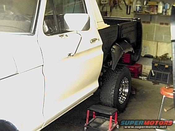 Side view of a white 1978 Ford Bronco with a black bed and chrome wheels