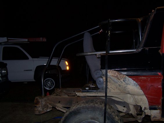 Customized truck interior with roll cage and seat, another white truck in background
