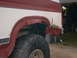 1986 Ford Bronco - Rear quarter panel of a 1986 Ford Bronco shows significant rust and damage.