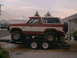 1986 Ford Bronco - A two-tone Ford Bronco is loaded onto a trailer, viewed from the side.
