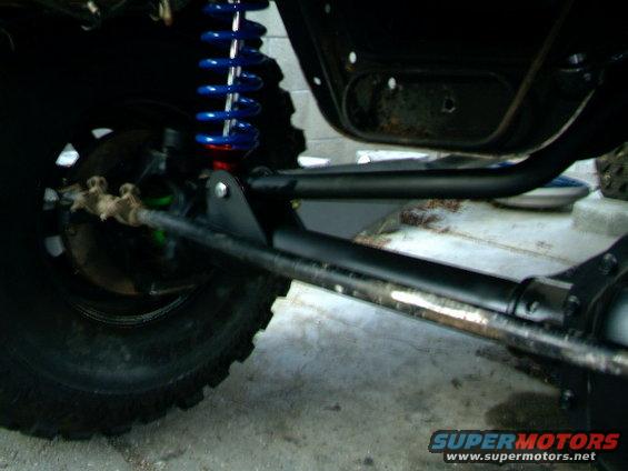 Close-up of off-road vehicle suspension with blue coilover shock and large tire
