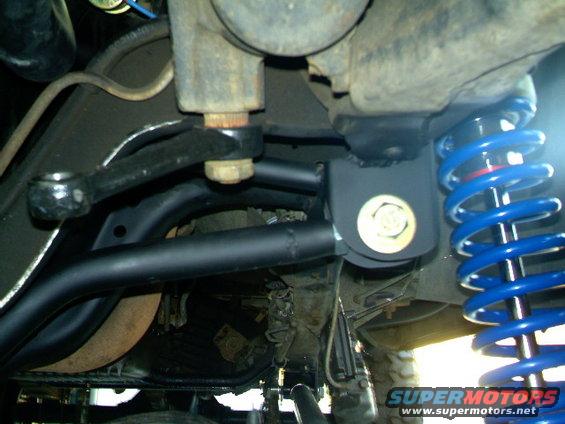 close-up of vehicle's front suspension with blue coilover shock and black control arms